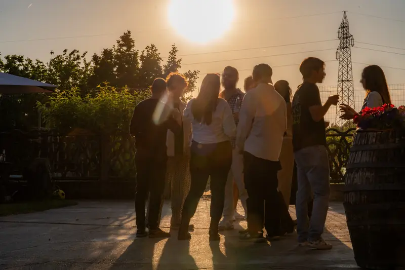 Gruppo di amici durante un aperitivo al tramonto in giardino