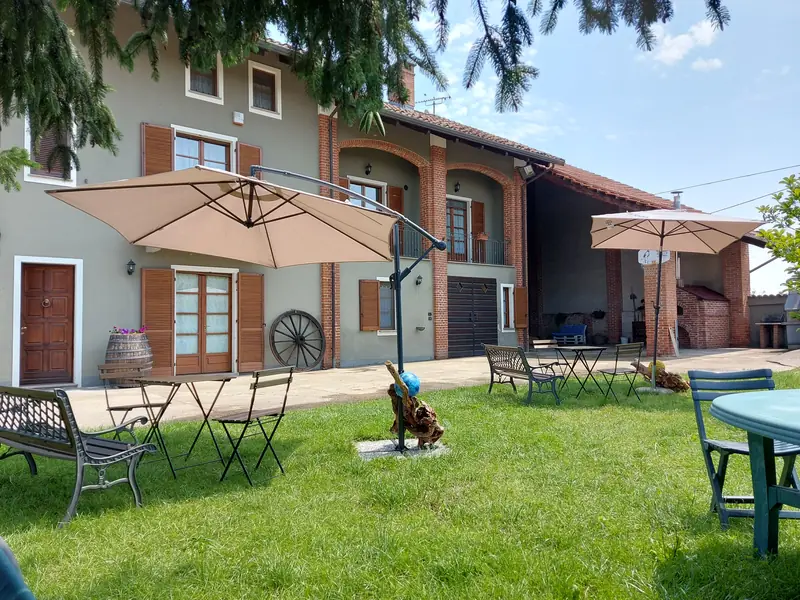 Sedute in giardino con la cascina sullo sfondo